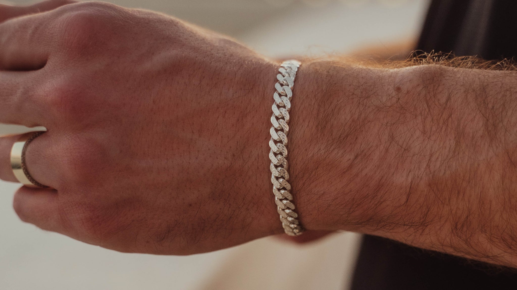 Man wearing a solid 925 sterling silver curb link bracelet with a gold ring — genuine silver bracelet from Liry's Jewelry